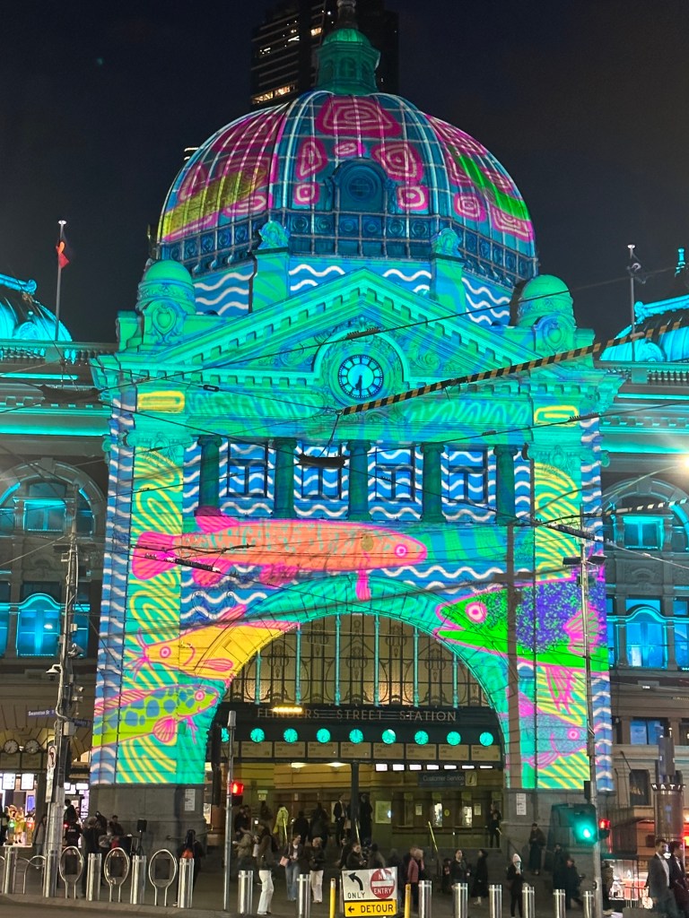 Brightly coloured fish projected across the exterior of Flinders Street Station.